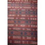 Persian woollen kilim rug having a rust coloured field,