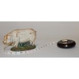 A small painted cast iron doorstop in the form of a pig together with a Chinese tape measure (2)