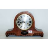 A 1930s oak cased mantel clock having a silvered dial with Roman numerals,