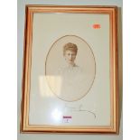 A framed tinted photograph of a young Princess Mary, later signed to the mount,
