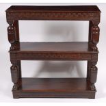 A 19th century oak three tier buffet, having carved frieze, raised on cup and cover supports, w.