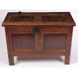 An 18th century joined oak coffer, having two panel hinged lid with later iron strapwork handles,