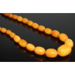 A beaded faux butterscotch amber single string necklace, largest bead width 3cm, gross weight 64g,