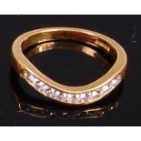 An 18ct gold and diamond set wishbone ring arranged as nine channel set brilliants,