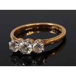 An 18ct gold diamond three stone ring, the centre claw set brilliant weighing approx. 0.