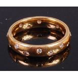 A contemporary 18ct gold diamond set band ring set with 16 small brilliants,