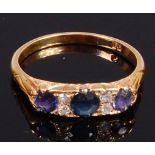 An 18ct gold, sapphire and diamond ring arranged as three round cut sapphires,