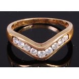 A modern 9ct gold diamond set wish bone ring, channel set with nine small brilliants,