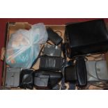 A box of cased and loose cameras,