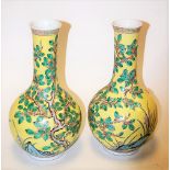 A pair of Chinese bottle vases, each on a yellow ground with blossoming prunus tree decoration, h.