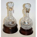 A pair of modern cut glass decanters and stoppers each having a silver collar and silver plated