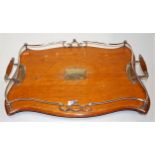 A George V oak and silver plated twin handled serving tray of serpentine form with presentation