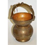 An Indian brass holy water carrier having all over engraved decoration,