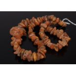 A natural unpolished amber necklace with loosely graduated rough cut sections, 106g,