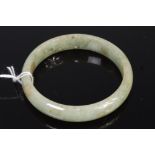 A Chinese jade bangle having russet inclusions 42.8g, dia.
