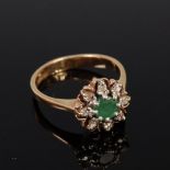 A 9ct gold, emerald and diamond flower head cluster ring, the round cut emerald weighing approx 0.