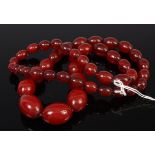 A beaded cherry amber necklace as graduated oval beads, gross weight 89g,