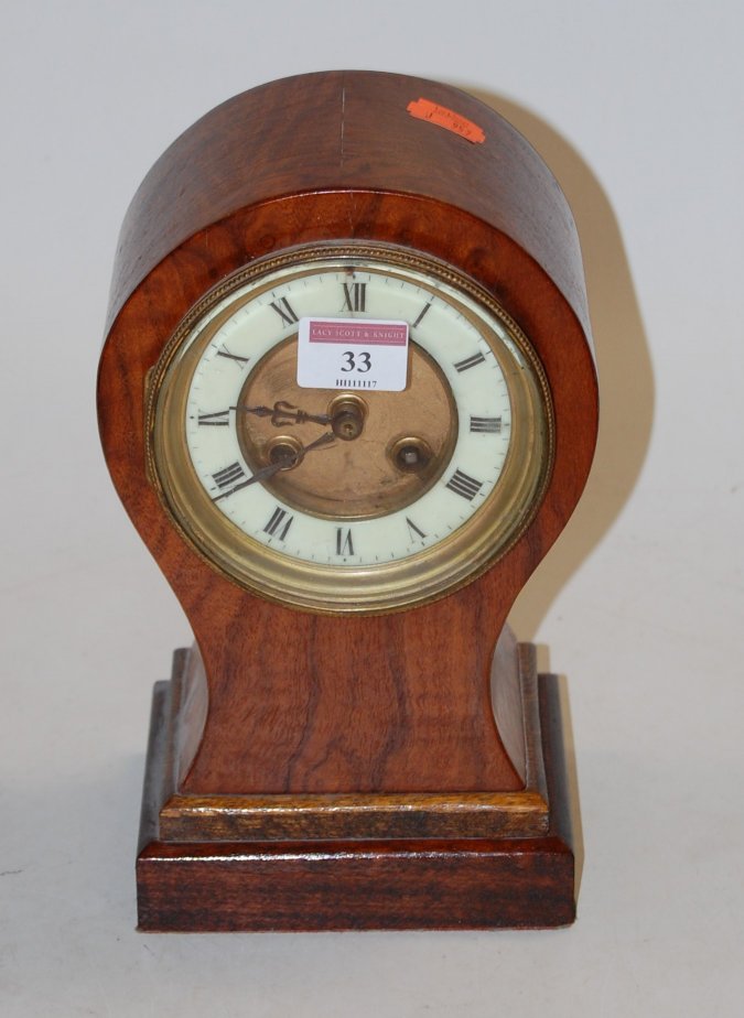 An Edwardian walnut balloon shaped mantel clock,