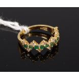 A modern 18ct gold emerald and diamond set half hoop ring, total emerald weight 0.