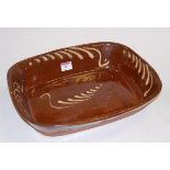 An early 20th century slip glazed pottery oven dish, w.