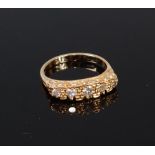 An 18ct gold and diamond set five stone ring, the graduated brilliants in a carved setting,