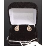 A pair of white metal and white sapphire set ear studs of pear shape