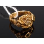 An 18ct gold and diamond set ring as three raised lozenge platforms on a knotted backdrop, 9g,