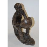 A carved and polished hardstone figure of a seated man playing an instrument, h.