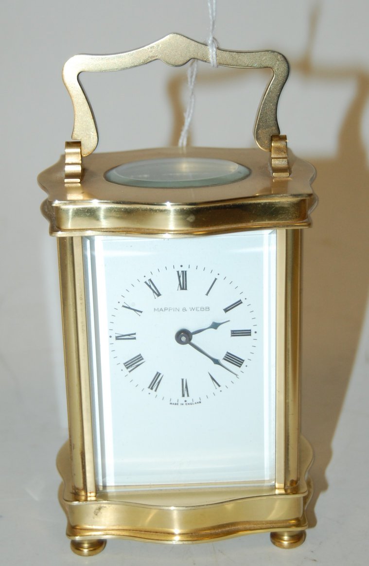 An early 20th century lacquered brass cased serpentine shaped carriage clock,