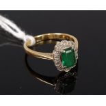 An 18ct gold and platinum emerald ring, the baguette cut four claw set emerald weighing approx 0.