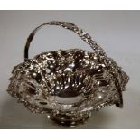 A Victorian silver plate on copper cake basket having spring handle and all over floral decoration