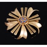 A modern engine turned 14ct gold and sapphire set flowerhead brooch, 6.4g, dia. 3.