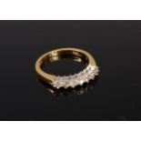 A modern 18ct gold diamond ring arranged as 7 claw set brilliants in a line setting,