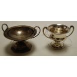 A silver pedestal twin handled trophy cup, and one other Arts & Crafts spot hammered example (2),