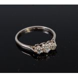 A platinum and diamond three stone ring, the claw set old cut diamonds in a line setting,