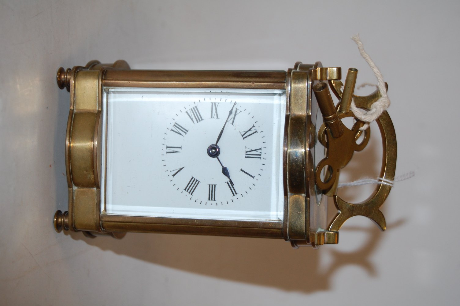 An early 20th century serpentine shaped lacquered brass cased carriage clock,