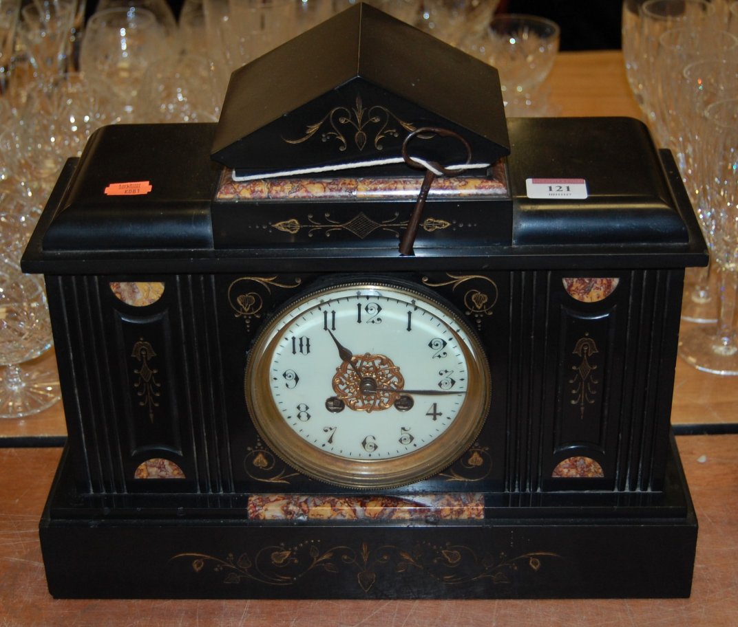 An Edwardian black slate and rouge marble cased mantel clock of architectural form having enamel