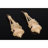 A pair of circa 1900 carved ivory ear pendants, each as a hanging urn issuing flowers, 5.