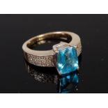 A 14ct gold blue topaz dress ring, the shoulders being pave set with small brilliant cut diamonds,