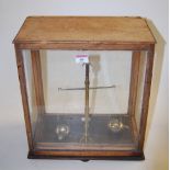 A set of Victorian lacquered brass beam scales, in glazed oak case, bearing label for W C Fanner,