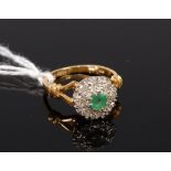 An 18ct gold emerald and diamond cluster ring, the centre round cut emerald weighing approx 0.