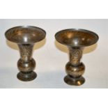 A pair of Indian brass trumpet shaped vases, with all-over incised decoration, h.