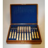 An Edwardian oak cased 12-place canteen of silver plated fish cutlery