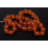 A beaded and graduated clear orange amber necklace on knotted string, 116g,