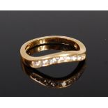 An 18ct gold and diamond set wishbone ring arranged as nine channel set brilliants,