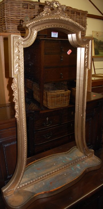 A French style giltwood wall mirror, of shaped form, having integral lower tray shelf,