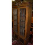 A 1930s oak lead glazed double door bookcase, having twin panelled lower cupboard doors, w.92.