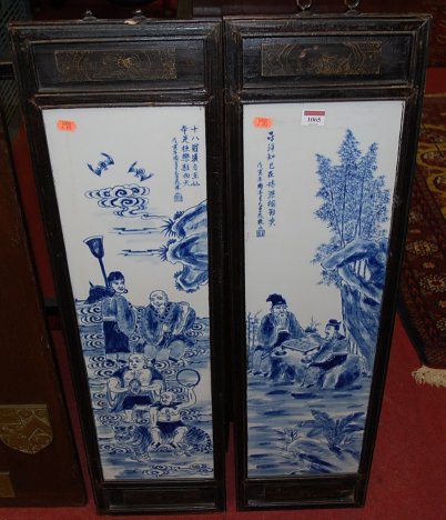 A pair of oriental underglazed blue decorated porcelain panels in ebonised frames,