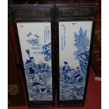 A pair of oriental underglazed blue decorated porcelain panels in ebonised frames,