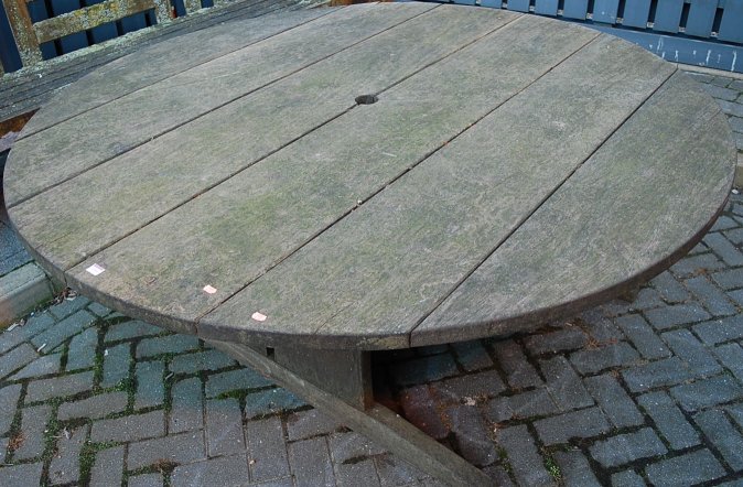 A large contemporary teak circular garden table, dia.